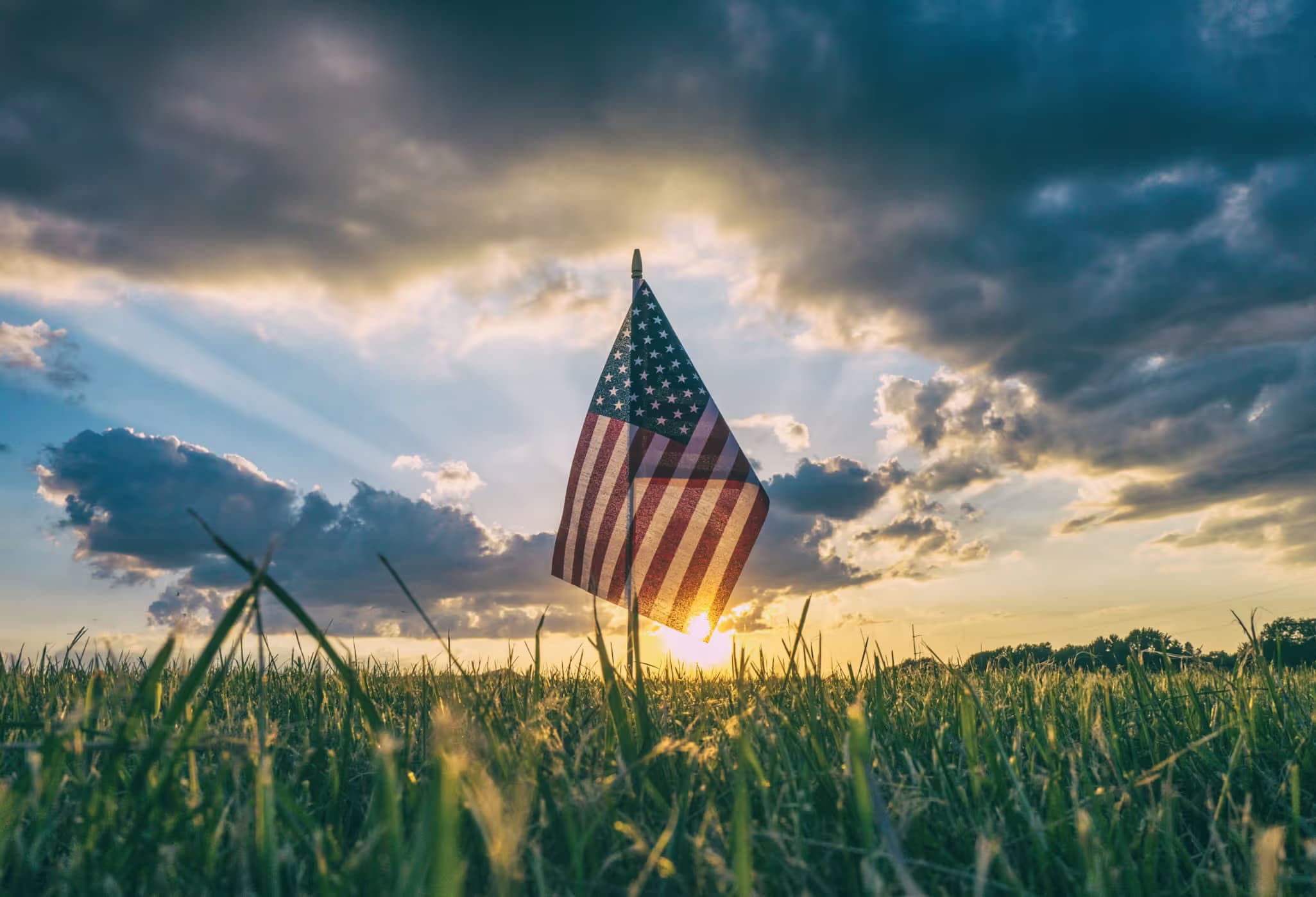 American Flag over a field of grass